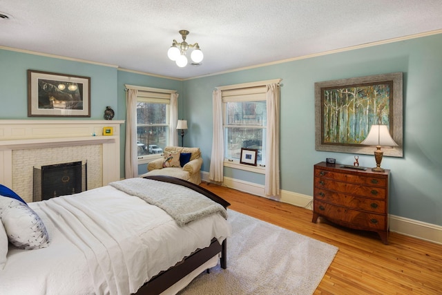 1767 Fremont Ave S, Minneapolis, MN 55403 - bedroom with ornamental molding, a textured ceiling, wood finished floors, a chandelier, and a fireplace