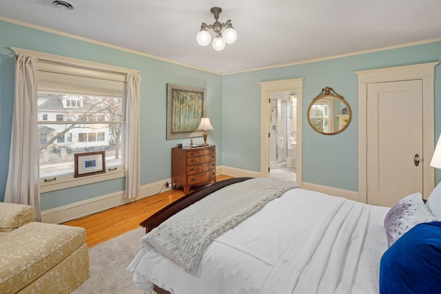 1767 Fremont Ave S, Minneapolis, MN 55403 - bedroom featuring ornamental molding, wood finished floors, a textured ceiling, connected bathroom, and a chandelier