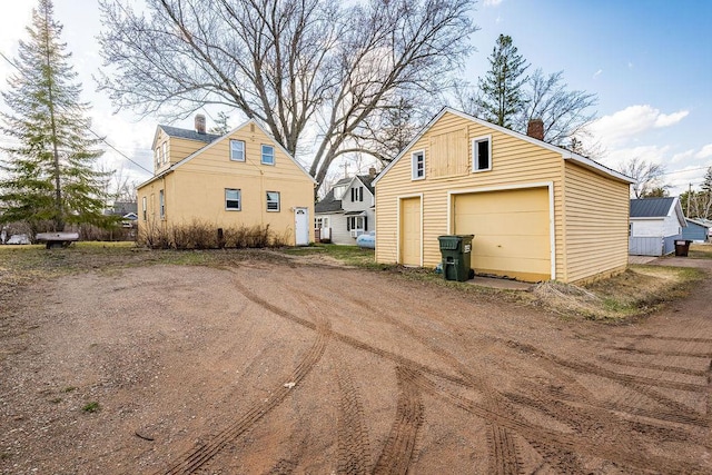 detached garage featuring dirt driveway