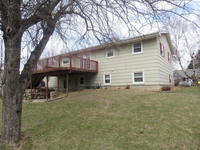 back of property with a yard, a deck, and stairway