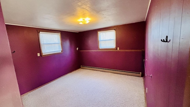 spare room featuring a baseboard radiator and carpet floors