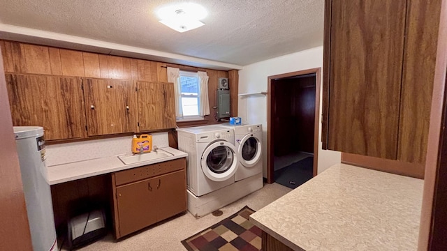 clothes washing area featuring water heater, washing machine and dryer, a textured ceiling, and a sink