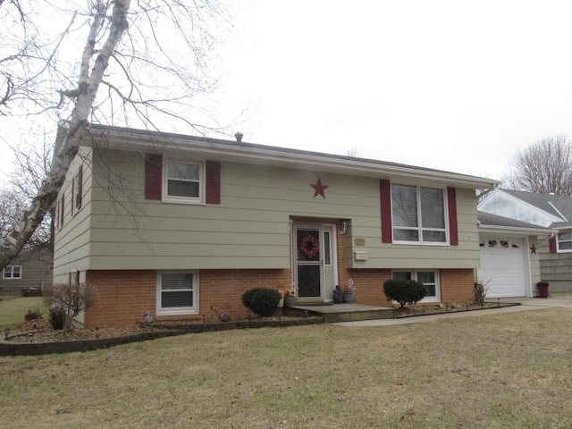 split foyer home with a garage, brick siding, and a front lawn