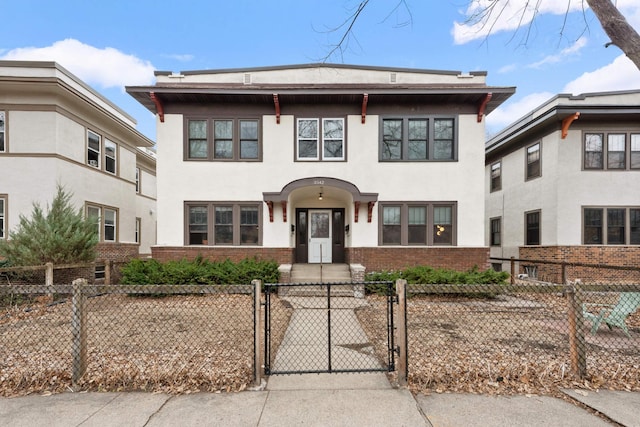 3542 Garfield Ave Unit 3, Minneapolis, MN 55408 - view of front of house featuring a gate, stucco siding, a fenced front yard, and brick siding