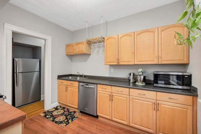 3542 Garfield Ave Unit 3, Minneapolis, MN 55408 - kitchen featuring stainless steel appliances, light brown cabinets, light wood-style flooring, and dark countertops