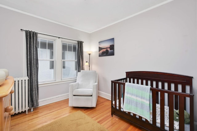 3542 Garfield Ave Unit 3, Minneapolis, MN 55408 - bedroom with radiator, wood finished floors, crown molding, and a nursery area