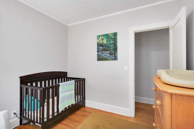 3542 Garfield Ave Unit 3, Minneapolis, MN 55408 - bedroom featuring wood finished floors, crown molding, and a crib