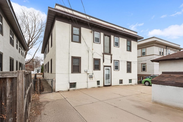3542 Garfield Ave Unit 3, Minneapolis, MN 55408 - rear view of property with stucco siding, a patio, and a gate