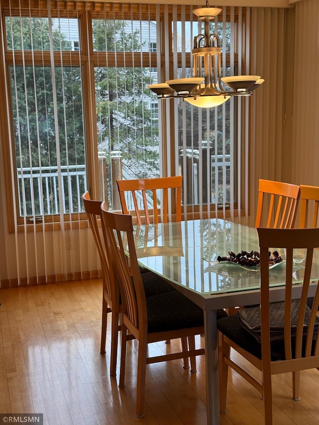 dining room with hardwood / wood-style flooring and a chandelier