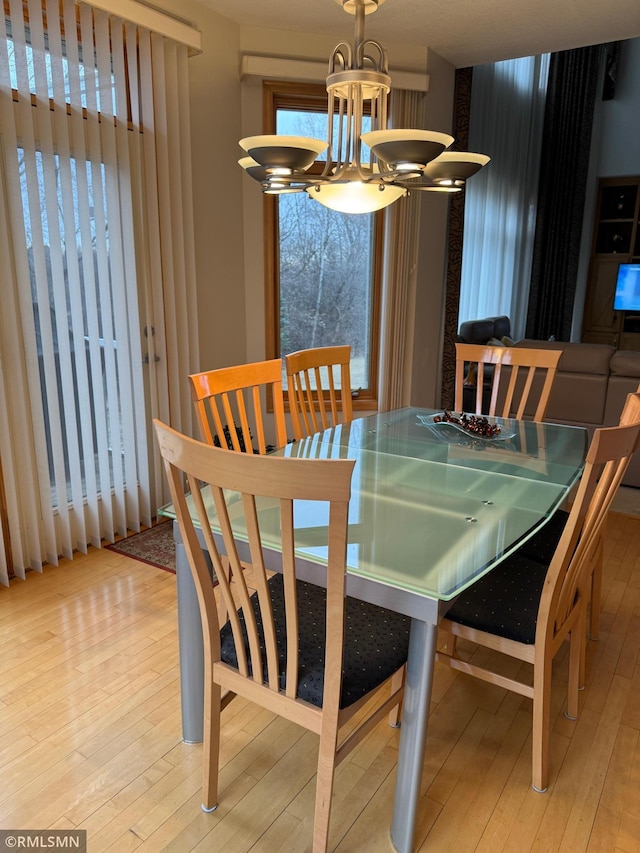dining area with hardwood / wood-style floors and a notable chandelier