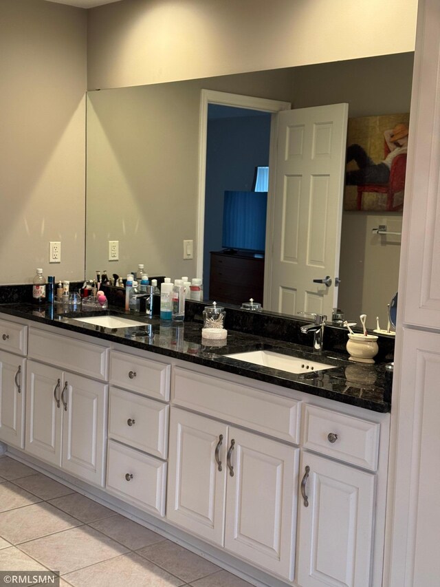 full bathroom with double vanity, tile patterned flooring, and a sink