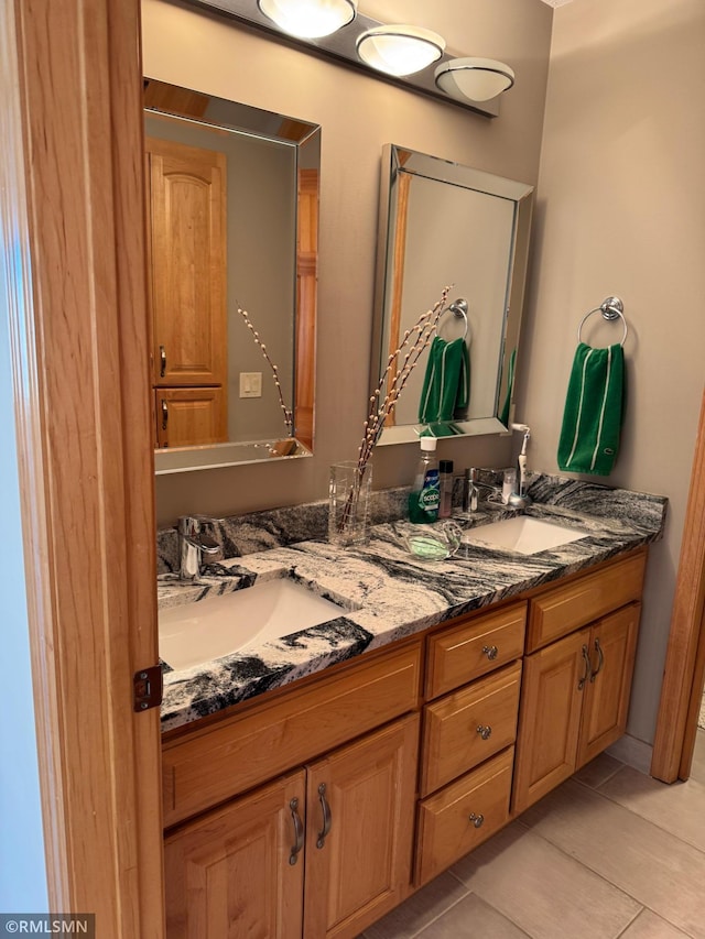 bathroom featuring double vanity, tile patterned flooring, and a sink