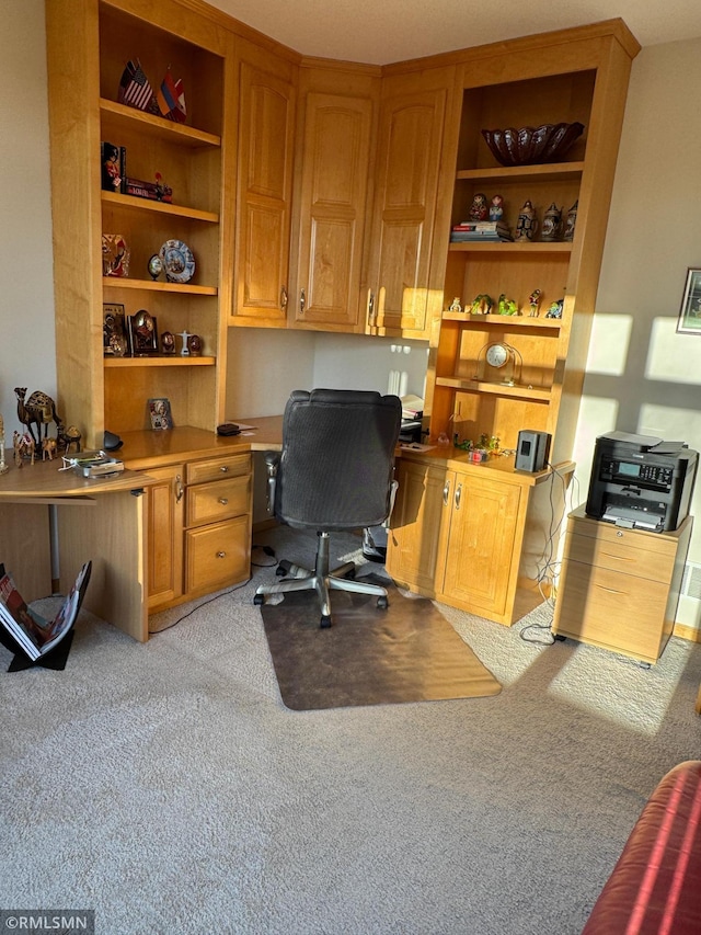 office space with built in desk and light colored carpet