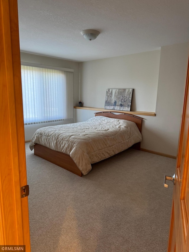 bedroom with baseboards and carpet flooring