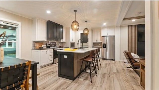 000 Pine Ave S, Sandstone, MN 55072 - kitchen with appliances with stainless steel finishes, decorative backsplash, light wood-style flooring, a breakfast bar area, and recessed lighting