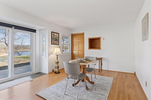 828 143rd St, Garfield Twp, WI 54001 - dining room featuring wood finished floors, a water view, and baseboards