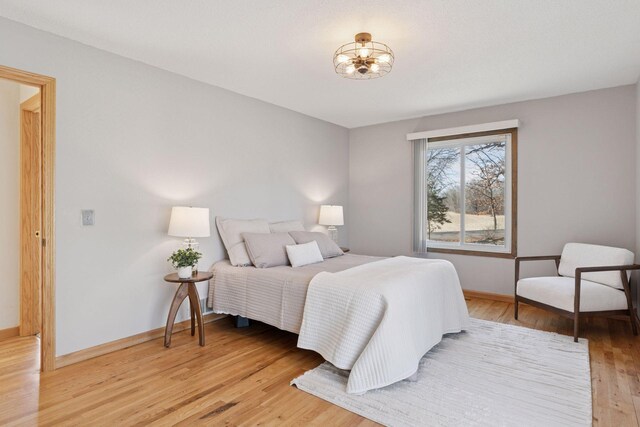 828 143rd St, Garfield Twp, WI 54001 - bedroom with light wood-style floors, a chandelier, and baseboards