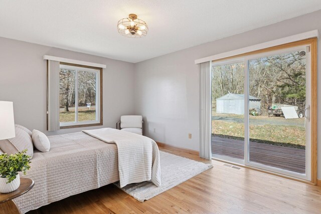 828 143rd St, Garfield Twp, WI 54001 - bedroom with access to exterior, multiple windows, wood finished floors, and baseboards