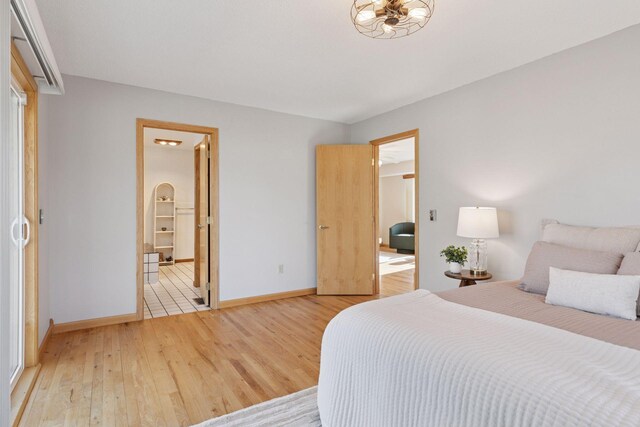 828 143rd St, Garfield Twp, WI 54001 - bedroom with light wood finished floors, baseboards, and ensuite bathroom