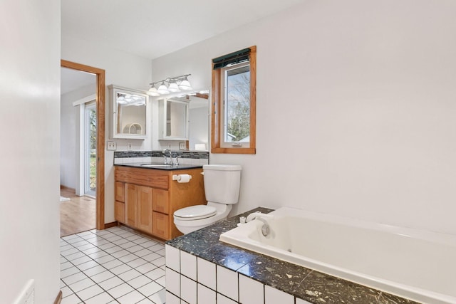 828 143rd St, Garfield Twp, WI 54001 - full bathroom featuring toilet, a garden tub, vanity, and tile patterned flooring