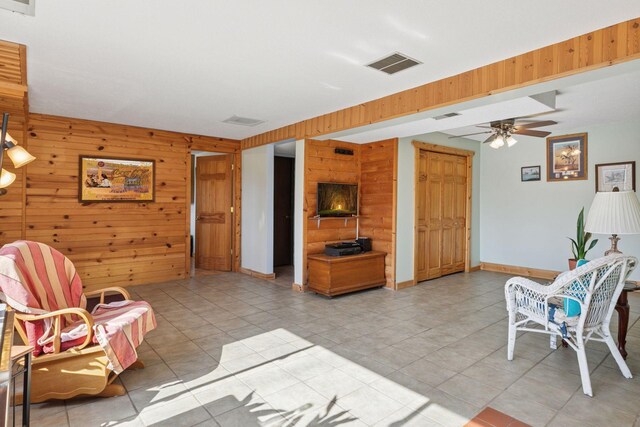 828 143rd St, Garfield Twp, WI 54001 - living area with wood walls, a ceiling fan, light tile patterned floors, and baseboards