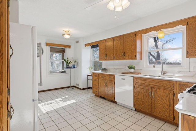 828 143rd St, Garfield Twp, WI 54001 - kitchen featuring white appliances, backsplash, light countertops, a sink, and healthy amount of natural light