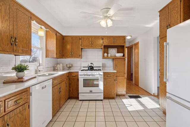 828 143rd St, Garfield Twp, WI 54001 - kitchen with white appliances, a sink, tasteful backsplash, light countertops, and brown cabinetry