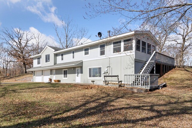 828 143rd St, Garfield Twp, WI 54001 - back of house with stairway, an attached garage, a wooden deck, and a sunroom