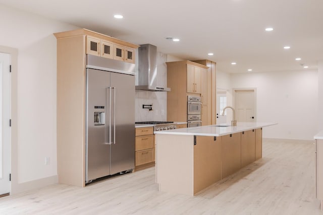 123 River View Rd, Ottertail, MN 56571 - kitchen with appliances with stainless steel finishes, wall chimney range hood, light wood-type flooring, light brown cabinetry, and recessed lighting