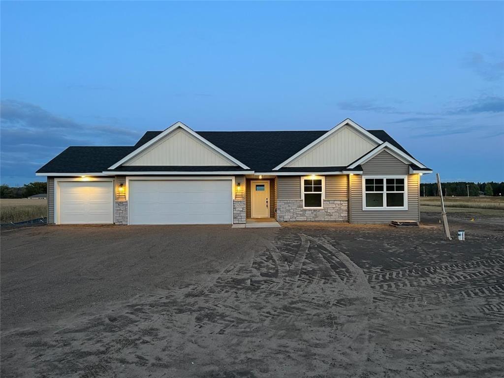 29395 144th St NW, Baldwin Twp, MN 55371 - view of front of home featuring stone siding, driveway, and an attached garage
