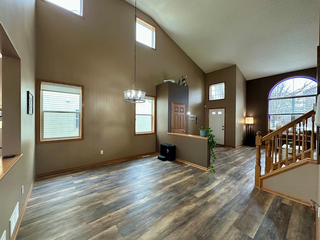 foyer with visible vents, a chandelier, wood finished floors, stairway, and high vaulted ceiling