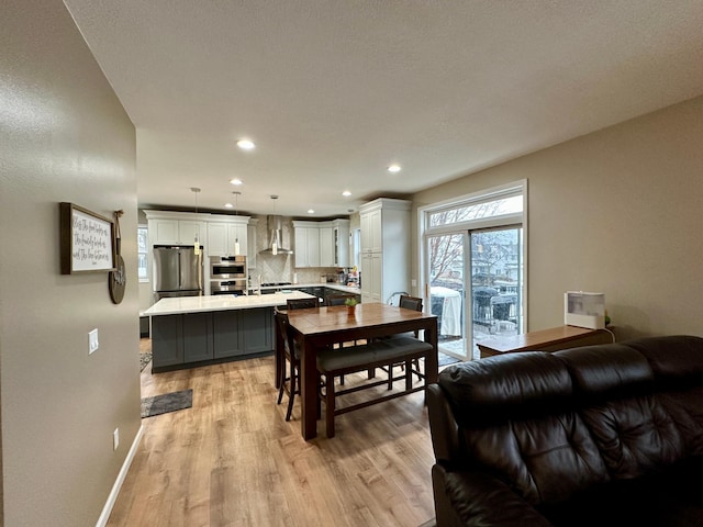 dining area featuring recessed lighting, light wood-type flooring, and baseboards