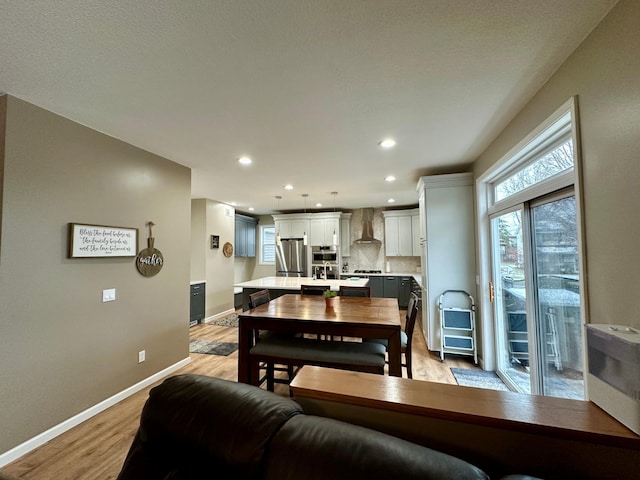 dining space featuring light wood-style flooring, baseboards, and recessed lighting