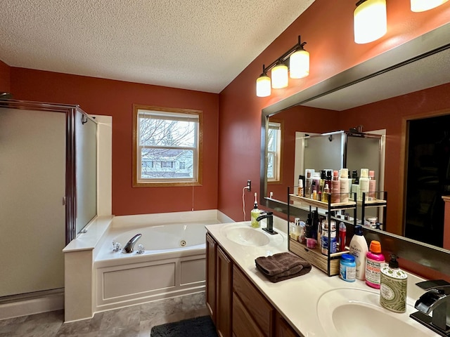bathroom with a whirlpool tub, a shower stall, a textured ceiling, and a sink