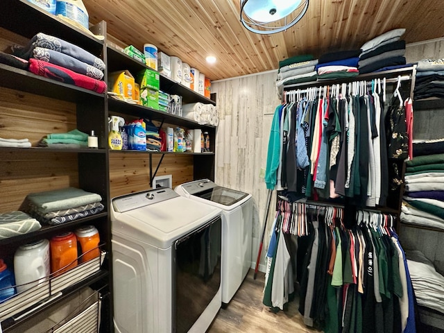 laundry area featuring wood finished floors, wooden walls, wooden ceiling, laundry area, and independent washer and dryer