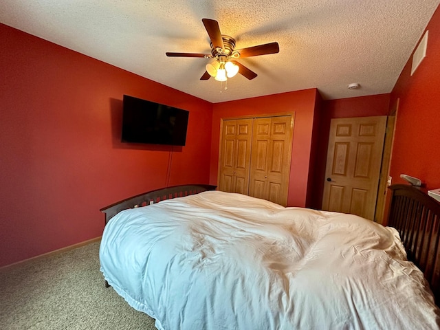 bedroom with a textured ceiling, carpet, a closet, and ceiling fan