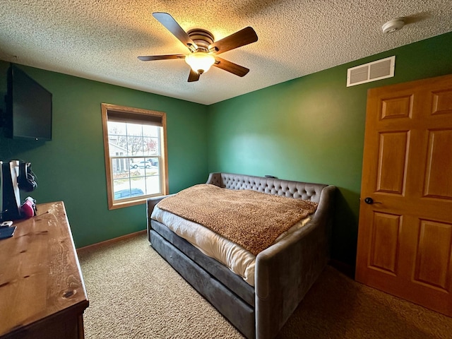 carpeted bedroom with a ceiling fan, visible vents, and a textured ceiling