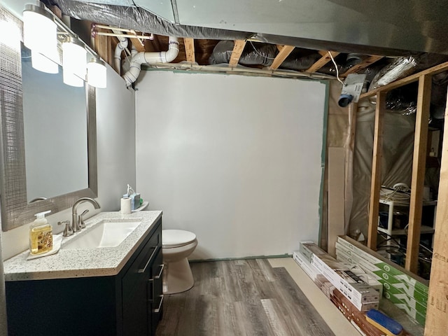 full bathroom featuring wood finished floors, toilet, vanity, and a shower