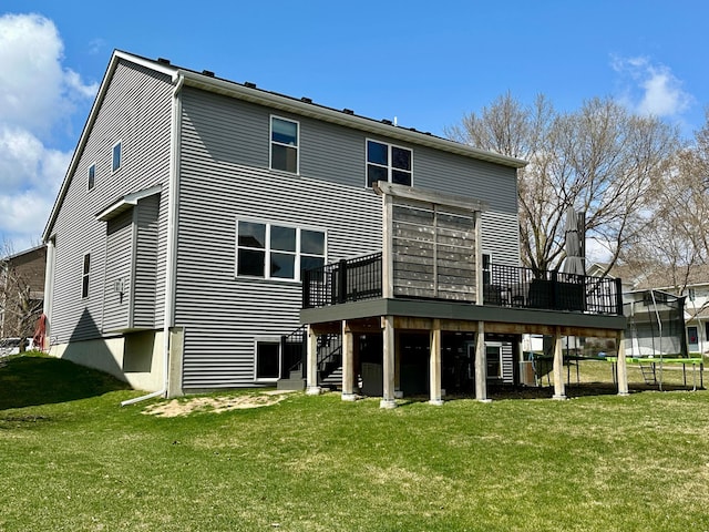 back of house with stairway, a wooden deck, and a lawn
