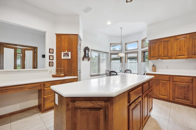 8991 Ferndale Ln, Eden Prairie, MN 55347 - kitchen with brown cabinets, light tile patterned floors, light countertops, and a center island with sink