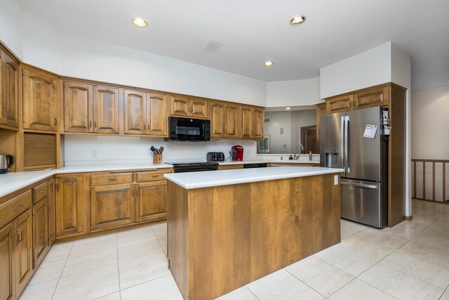 8991 Ferndale Ln, Eden Prairie, MN 55347 - kitchen with stainless steel fridge, black microwave, light tile patterned floors, light countertops, and brown cabinets