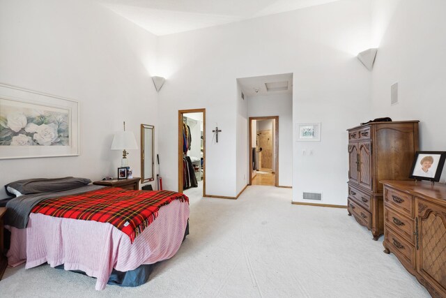 8991 Ferndale Ln, Eden Prairie, MN 55347 - bedroom featuring a towering ceiling, a spacious closet, attic access, visible vents, and light colored carpet