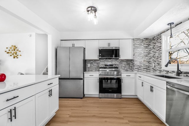 493 Rolls Rd, New Brighton, MN 55112 - kitchen featuring appliances with stainless steel finishes, a sink, decorative backsplash, white cabinets, and light countertops