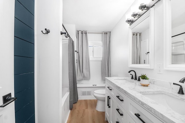 493 Rolls Rd, New Brighton, MN 55112 - bathroom with toilet, double vanity, wood finished floors, and shower / bathtub combination with curtain