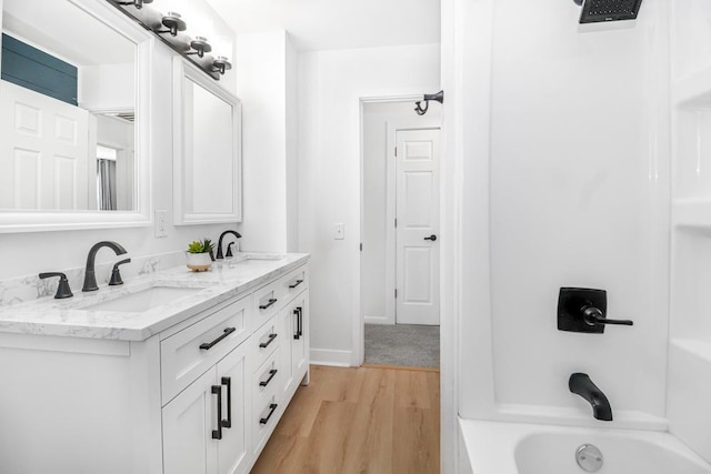 493 Rolls Rd, New Brighton, MN 55112 - full bathroom featuring double vanity, wood finished floors, shower / tub combination, and baseboards