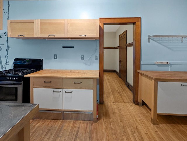 3441 Portland Ave Unit 2, Minneapolis, MN 55407 - kitchen featuring stainless steel gas stove, light wood-style floors, wooden counters, and baseboards