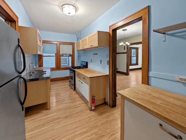 3441 Portland Ave Unit 2, Minneapolis, MN 55407 - kitchen featuring stainless steel gas stove, freestanding refrigerator, wooden counters, a sink, and light wood-type flooring