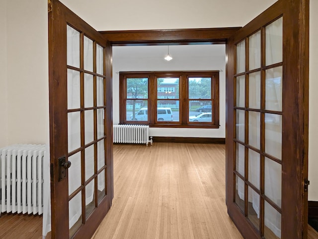 3441 Portland Ave Unit 2, Minneapolis, MN 55407 - corridor with radiator heating unit, wood finished floors, french doors, and baseboards