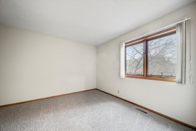 carpeted spare room with baseboards and visible vents