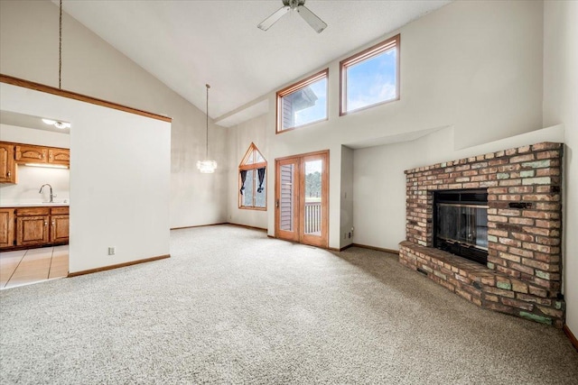 unfurnished living room featuring light carpet, a brick fireplace, high vaulted ceiling, and ceiling fan